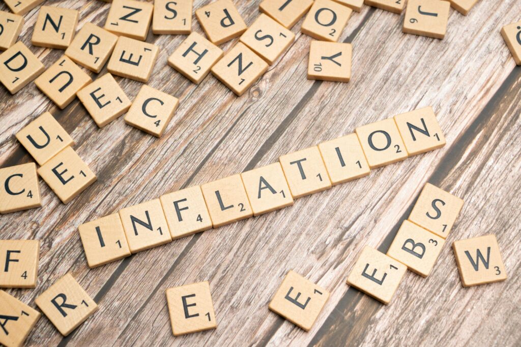 Wooden letter tiles forming the word 'inflation' on a rustic wooden surface, symbolizing economic themes.