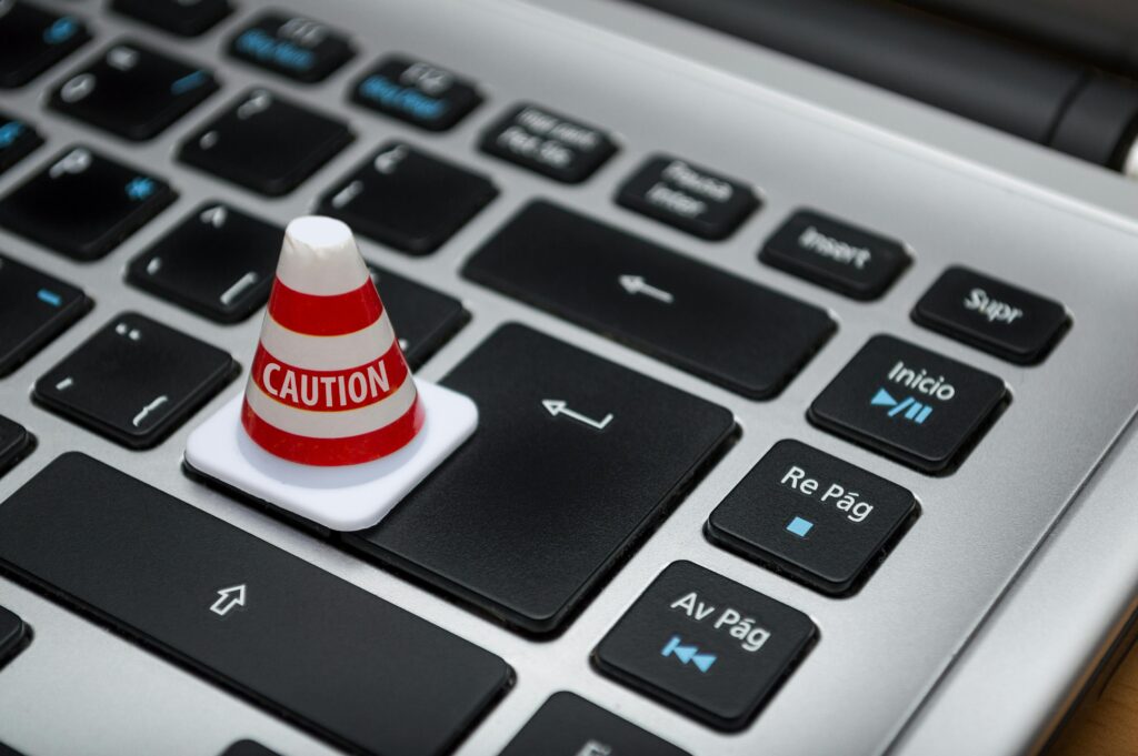 Miniature caution cone on a computer keyboard symbolizing data security and control.