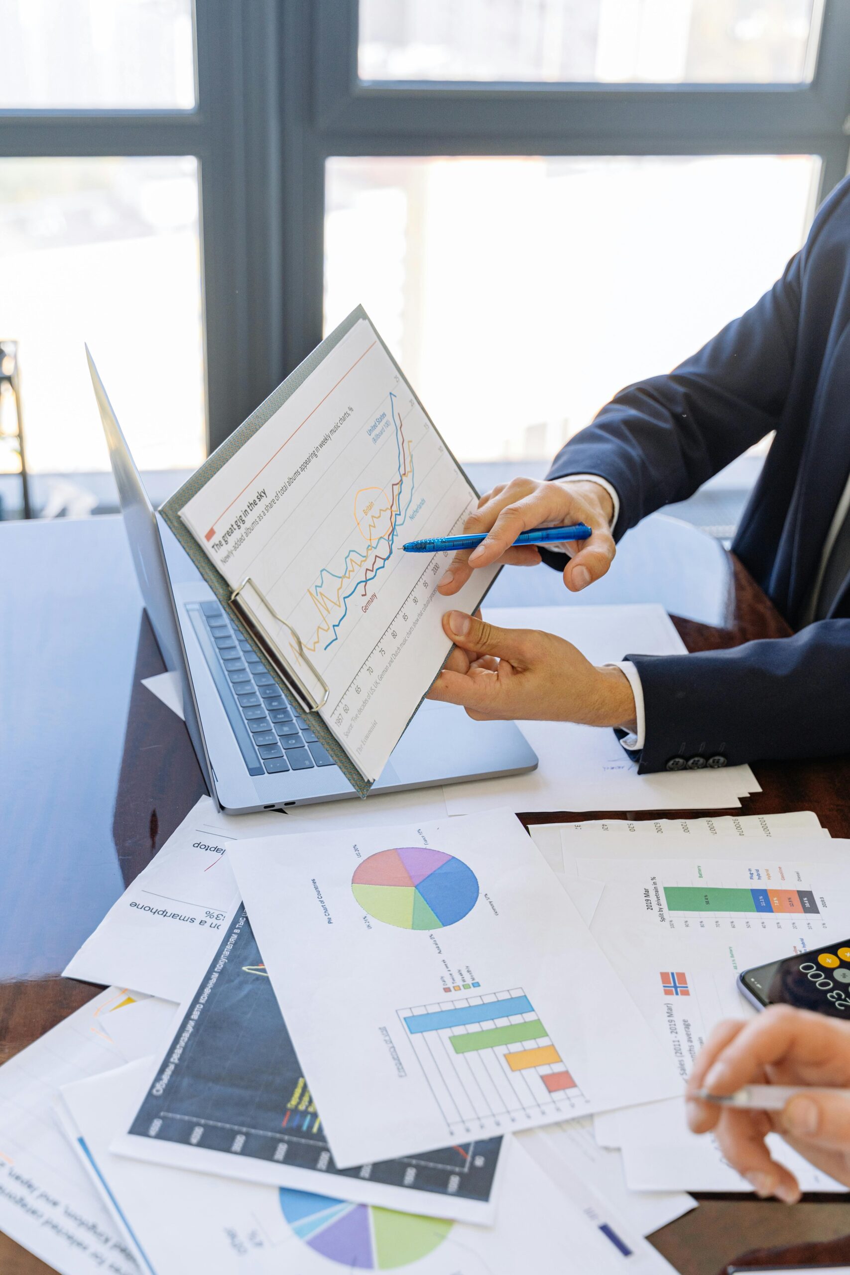 Business professionals discussing financial graphs and charts in an office setting.